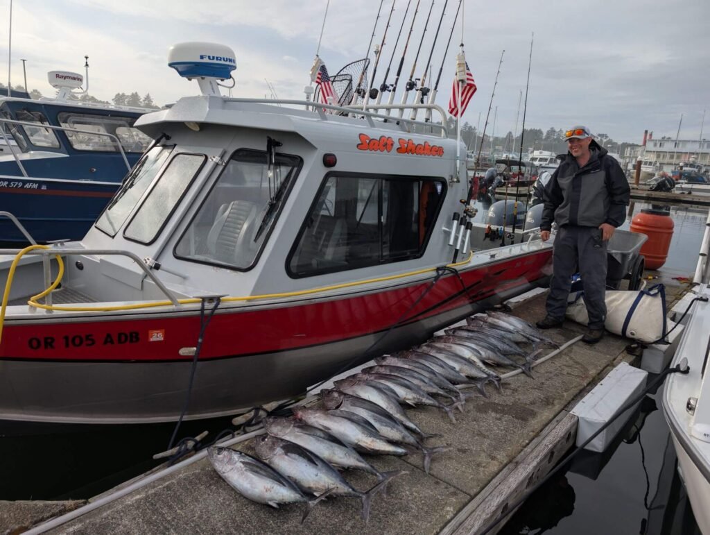 Salt Shaker charter fishing boat docked beside a large lineup of freshly caught albacore tuna.